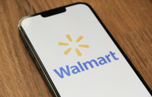 Logotipo do Walmart exibido em smartphone, representando a parceria entre Walmart e OpenAI para criar experiências de compra com IA.